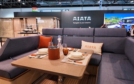 U-shaped cockpit dinette on the Aiata Sunfinder 50 with table set for dining under the hardtop.