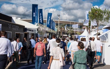 Overview of visitors at the Cannes Yachting Festival walking along a row of exhibitors.