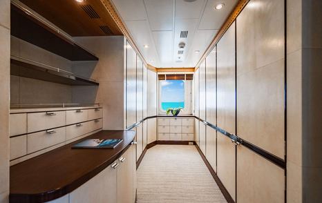 Motor yacht Nita K's walk-in wardrobe with teak panelling and sea views