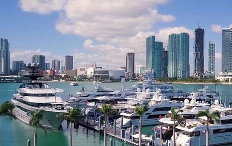 Overview of Yacht Haven Grande Miami at Island Gardens, motor yachts moored with Miami skyline in background 