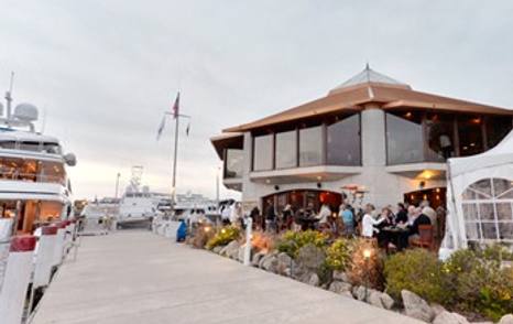 Restaurant at Daytona Marina & Boat Works – Daytona Beach, guests enjoying drinks outside, with motor yachts moored directly opposite