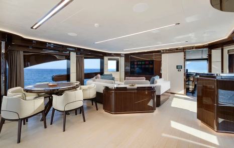 Lazzara UHV 100 Motor Yacht upper deck salon with wooden features and mounted TV