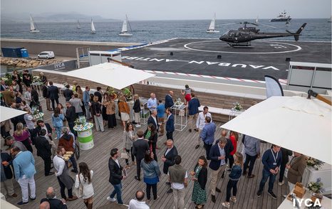 Outdoor party for the International Yacht Club d’Antibes (IYCA) grand opening. Visitors out on the dock with drinks.