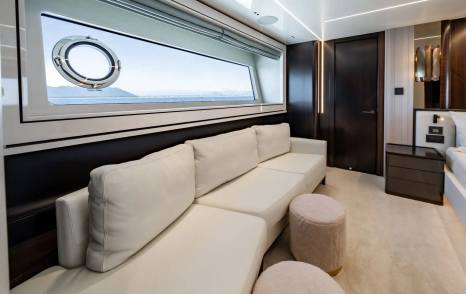 Motor Yacht Triple Eight master cabin sofa area and large porthole window