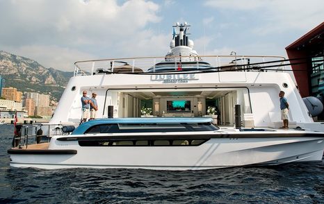 Tender boat in front of mothership with two people on main yacht