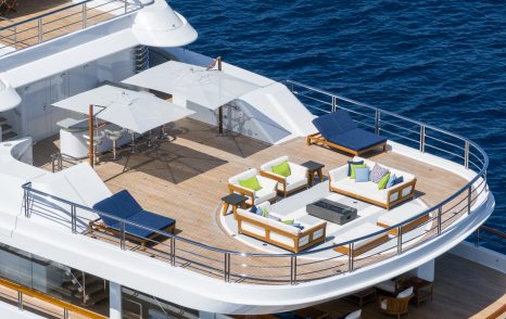 Superyacht Rocinante's upper aft deck with seating and shaded alfresco dining