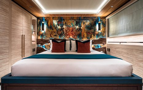Guest cabin on motor yacht King Benji with double bed, jungle prints and wooden panelling