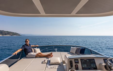 Sunpads on Absolute 50Fly flybridge, Owner relaxing on sunpad looking out at the view, surrounded by sea