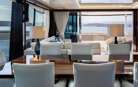 Motor Yacht Triple Eight main saloon seating area with large windows and neutral furnishings