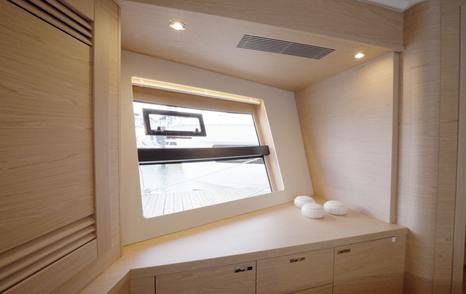 Beneteau Grand Trawler 63 VIP cabin with dressing area, hull window and built-in cabinetry