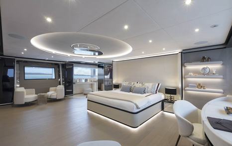 Master cabin onboard Mangusta Oceano 50. Central berth with dressing table at forefront and small lounge area to port.