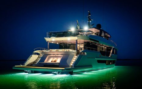 Aft view of the Gulf Craft Majesty 100 Terrace illuminated at anchor at night
