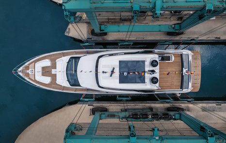 Ferretti Yachts 860 hitting the water for the first time via lifting mechanism. Bird's eye view looking down on yacht.