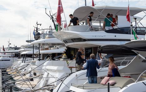 Azimut motor yachts on display at the Genoa International Boat Show with visitors looking around