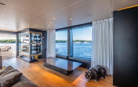 Motor yacht Le Gypsy main saloon cushioned window seating and marbled coffee table 