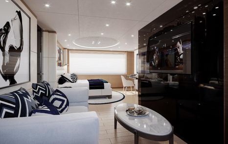 Light colored sofa and table in cabin on yacht, with dark cabinet in background.