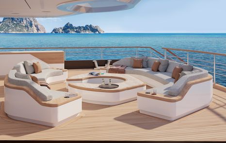 Exterior seating area onboard the Moonflower 72, circular seats surround a coffee table, with sea visible all around.