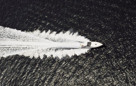 aerial greyscale shot motor yacht at speed