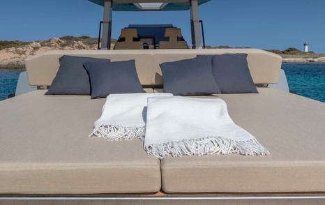 Double sunpad onboard Wally 48 Wallytender, with four blue cushions and white throws for display.