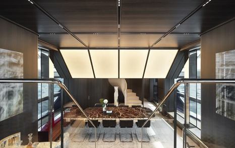 Superyacht Contigo main saloon with glass staircase and wooden dining table