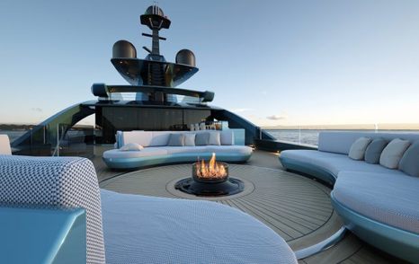 rendering of a fire pit surrounded by curved sofas on the sundeck of S702 model 