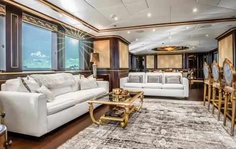 Superyacht Status Quo's main saloon with white sofas and glass coffee table