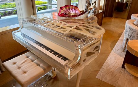 Transparent grand piano inside the main saloon of the Amels 242 Casino Royale luxury superyacht.