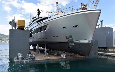 Side view of Sanlorenzo 44Alloy H1 during launch ceremony, surrounded by construction equipment and sea