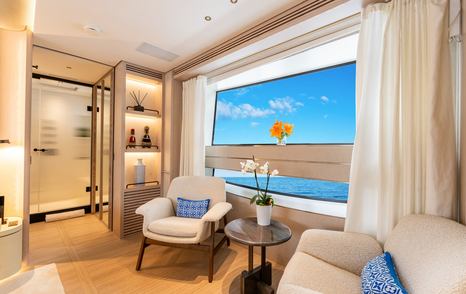 Spacious cream armchairs and sea views on board superyacht A+