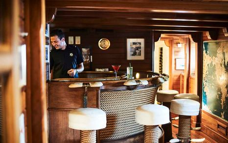 Superyacht Christina O interior bar area with worker