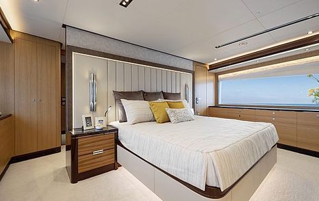 Master cabin onboard Horizon TO-KALON, central berth and night stand, with wide window on far side