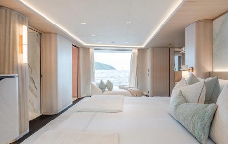 Large bed with blue cushions and sea-view on superyacht M