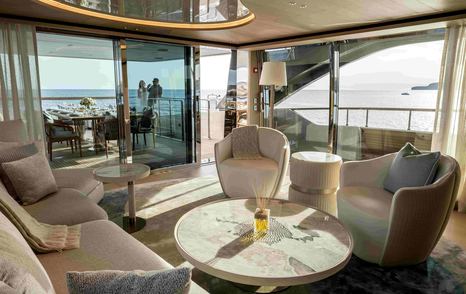 Superyacht Unique S upper deck lounge with white seating and circular coffee table 