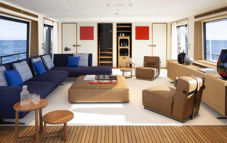 Motor yacht Numero Dix main saloon L-shaped blue seating and brown armchairs