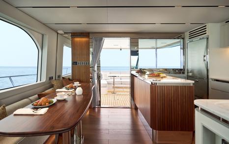 CL Yachts CLB65 SUV Motor Yacht salon aft with wooden dining table and breakfast bar