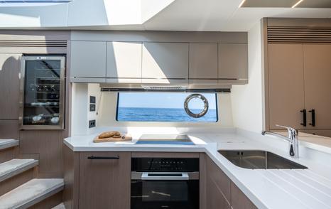 The lower galley onboard the Sunseeker 75 Sport Yacht, sink unit and oven visible with window in background.