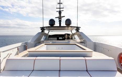 Alia Superyacht Ximena sundeck with empty jacuzzi and surrounding grey sunpads 