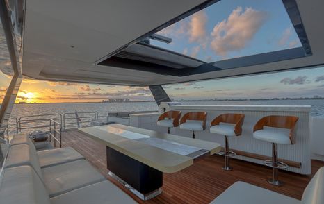 Motor Yacht Saint flybridge seating area with bar stools, table and open ocean views