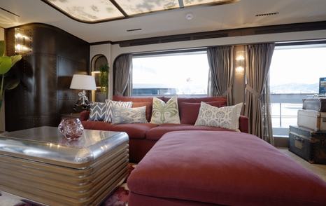 Sirena 118 upper saloon seating with red sofas and bespoke lighting