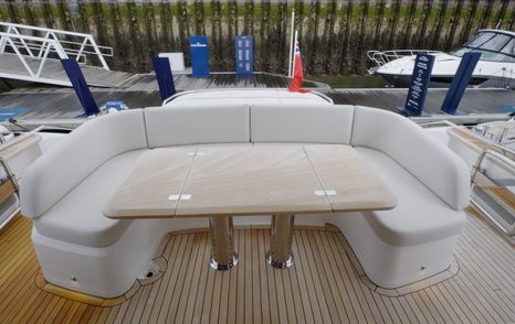 Princess S65 Mk2 cockpit dining area with U-shaped seating and folding teak table