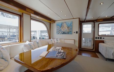 Nordhavn 75 EYF saloon dining area with panoramic windows and aft cockpit access