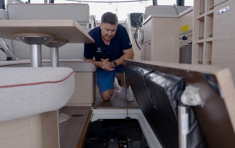 Jack Haines accessing the engine compartment through the saloon floor on the Beneteau Swift Trawler 37 Fly