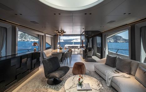 Mangusta 104 REV motor yacht main saloon seating area with white sofa and white marbled coffee table 