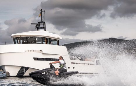 YXT 24 Evolution at sea with jetski speeding through foreground, overcast sky above