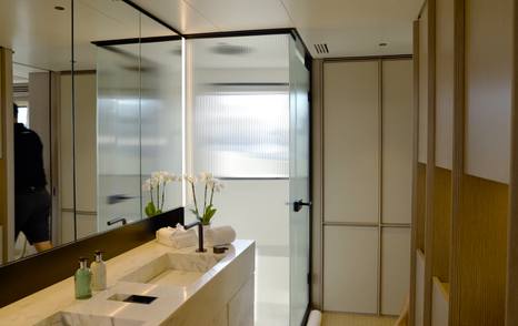Benetti Oasis 34M owner's ensuite bathroom with twin washbasins, walk-in shower and full-height mirrors.