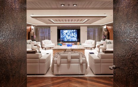 Superyacht Luna saloon with cream furniture and mounted TV