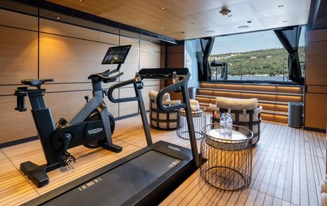 Superyacht Reliance beach club interior with indoor gym equipment 