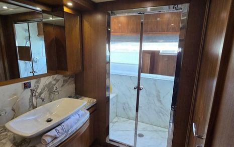 Bleu Blanc en suite bathroom with sink, marble finishes, and glass shower