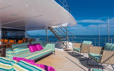 Superyacht Chrimi III's aft deck with seating and shaded dining area