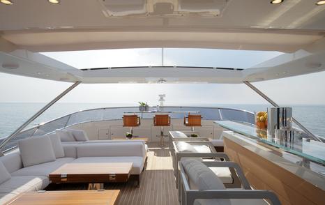 Superyacht Inspiration's upper deck with seating and bar area